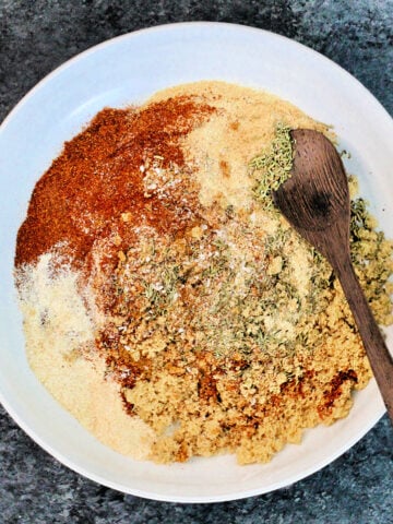 A bowl of the Best Ever Salmon Dry Rub with a wooden spoon.