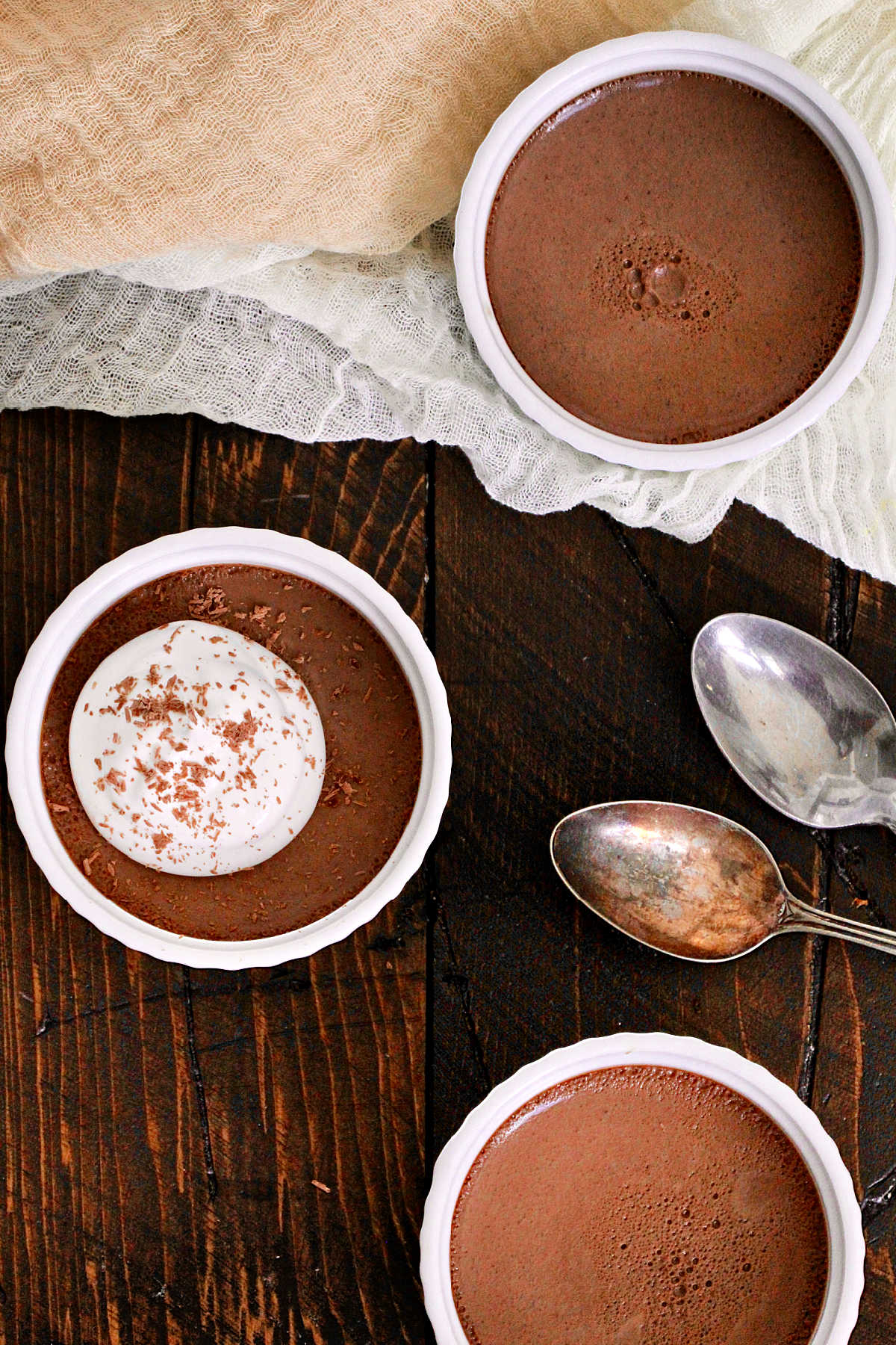 Chocolate Espresso Pots de Crème in white ramekins with silver spoons nearby.