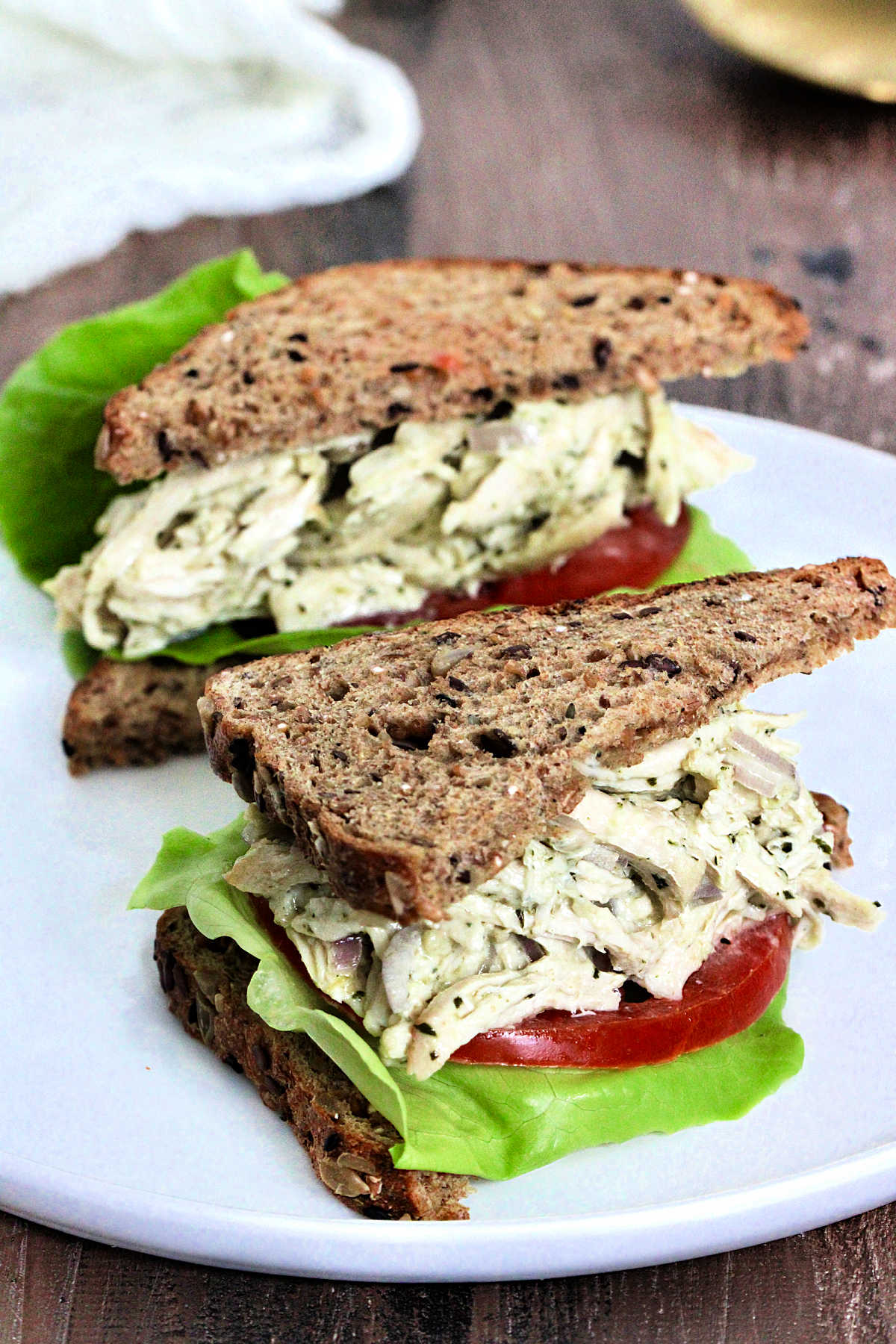 Pesto chicken salad sandwiches on a white plate.