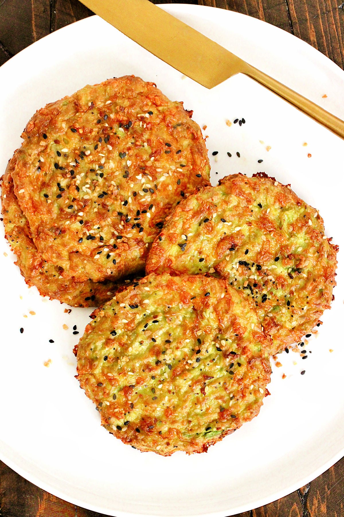 Pieces of avocado bread on a white plate with a gold knife.