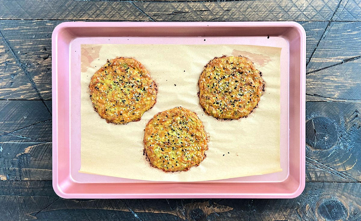 Pieces of avocado bread on a pink sheet pan on a wooden board.
