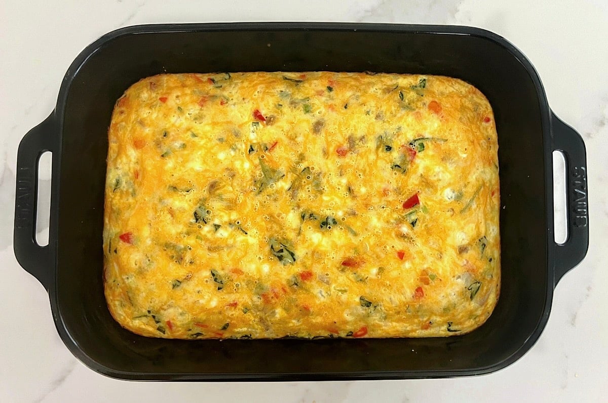 A fully cooked high protein cottage cheese egg bake in a black rectangular baking dish.