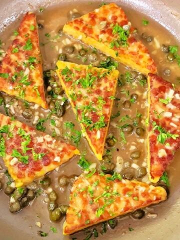 Vegan tempeh piccata finished in skillet with lemon caper sauce
